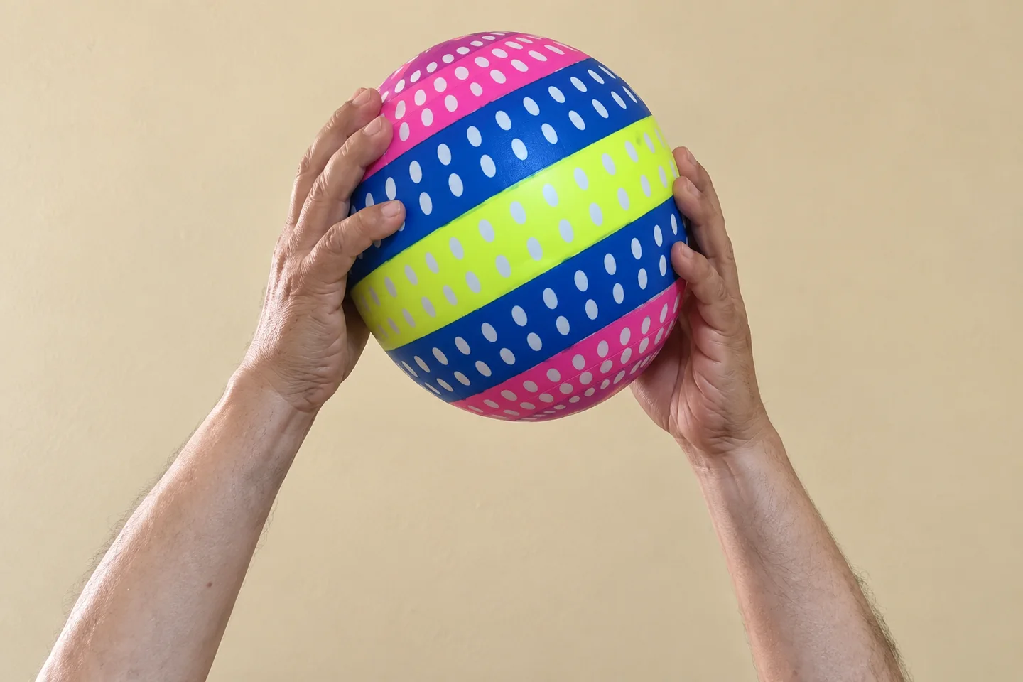 Manos sosteniendo una pelota de ejercicio.
